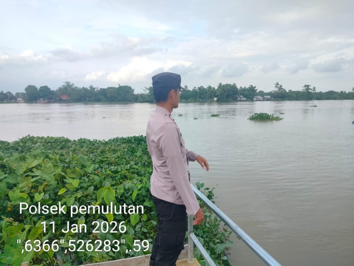 Anggota Bhabinkamtibmas Polsek Pemulutan Cek Arus dan Debit Air Sungai, Antisipasi Banjir di Wilayah Rawan